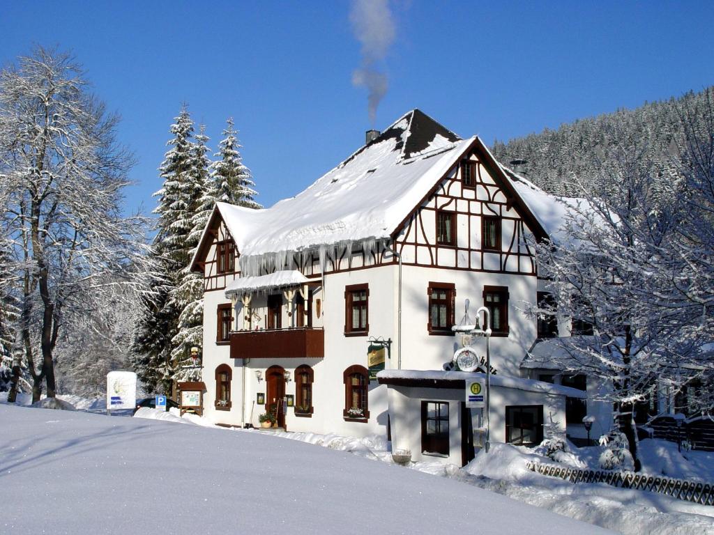 WildenthalGasthof und Pension Hammerschänke的一座大房子上面有雪