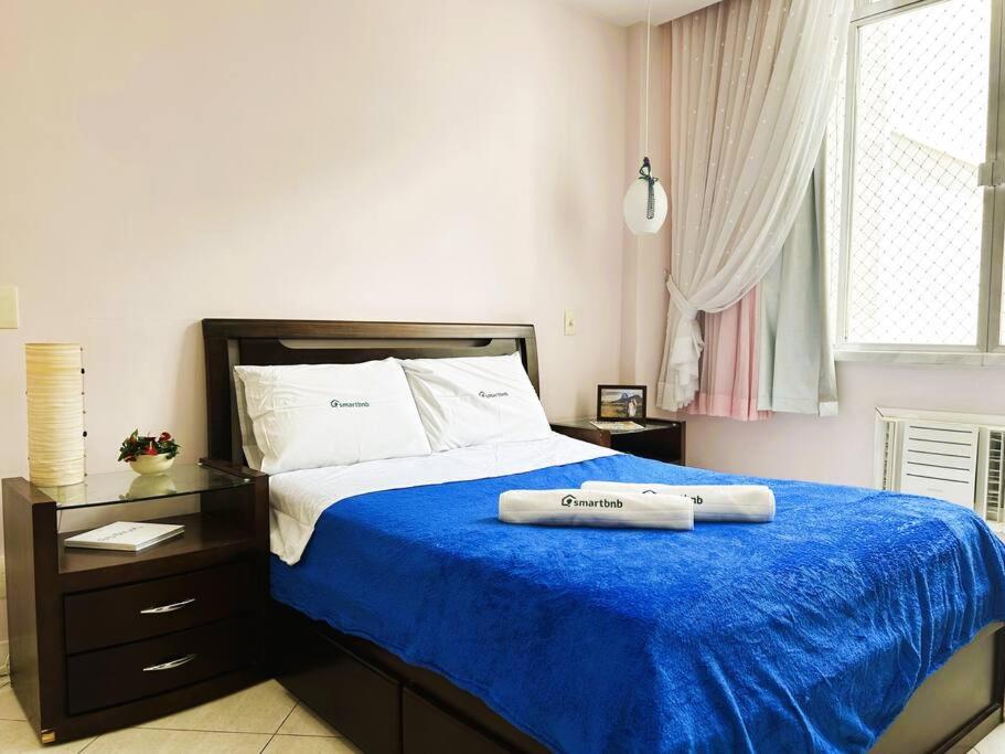 里约热内卢Charme do Leme的一间卧室配有一张带蓝色毯子的大床