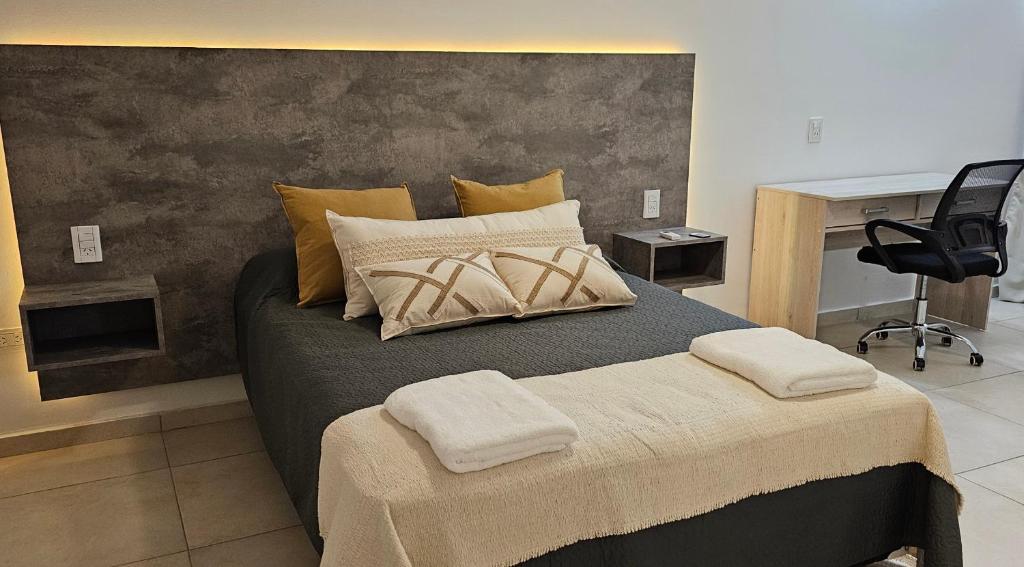 普洛缇尔Complejo Hunter Plottier - Neuquén的一间卧室配有一张带两个枕头的床