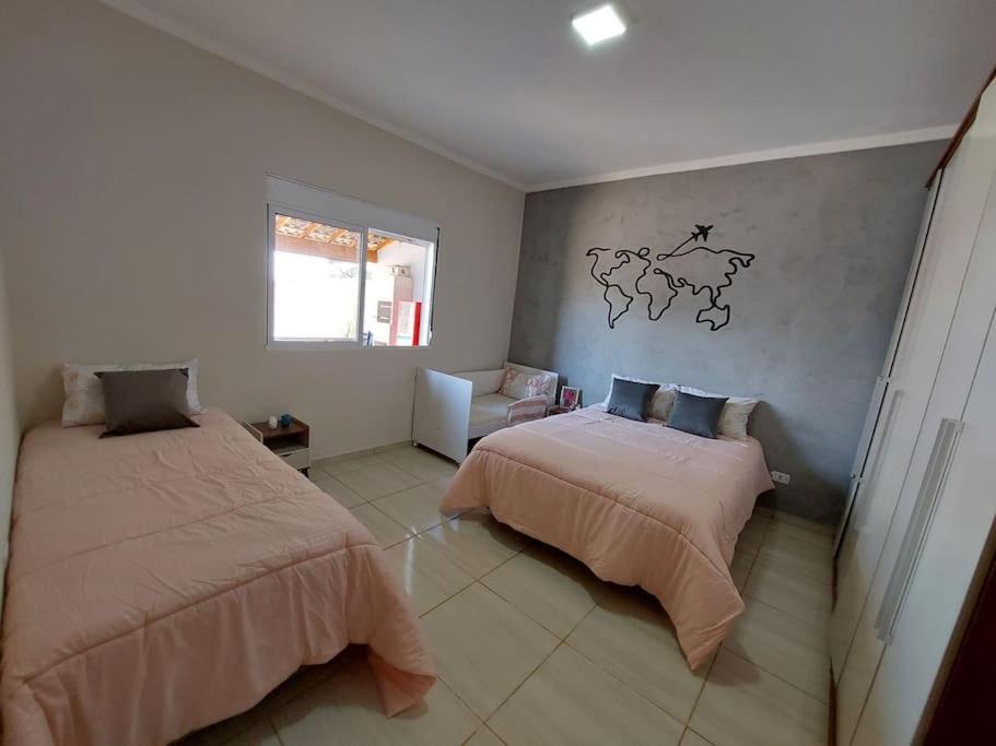 博伊图瓦Vivenda Bela Vista的卧室配有两张床,墙上挂有地图