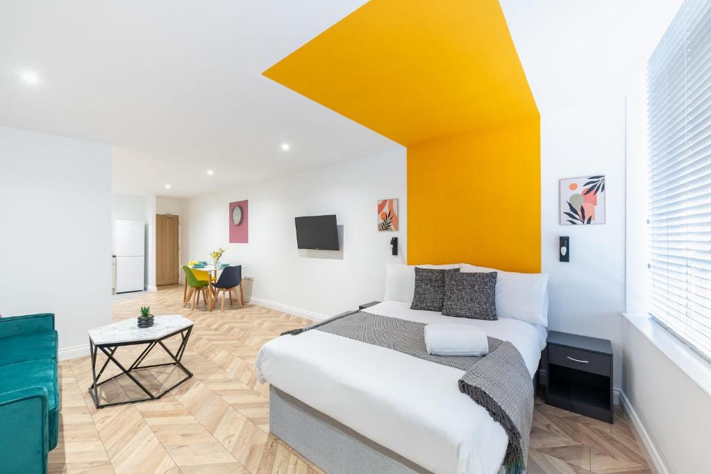朴次茅斯Paradise Suite的一间卧室设有一张床和黄色的墙壁