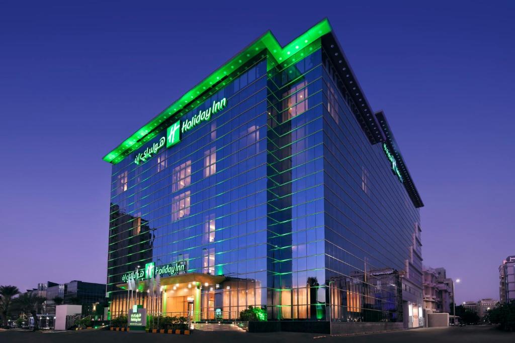 吉达Holiday Inn Jeddah Corniche, an IHG Hotel的上面有绿色标志的建筑