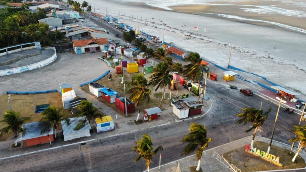 马如达Linda casa em marudá的享有海滩的空中景致,海滩上种有房屋和棕榈树
