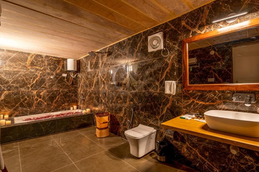 斋沙默尔Sam dunes desert safari camp的一间带水槽、卫生间和镜子的浴室