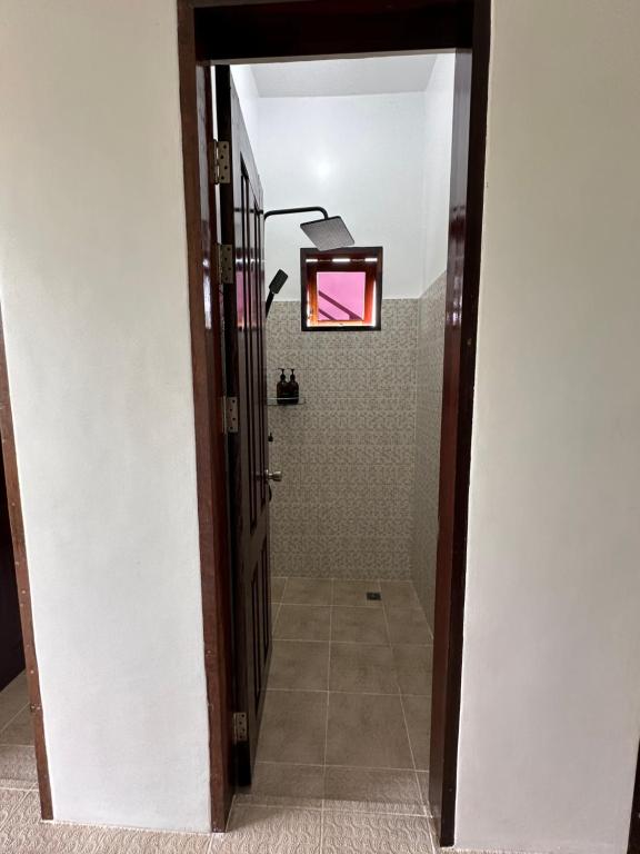 卢纳将军城Haven Suites Siargao的走廊设有带淋浴的浴室和门