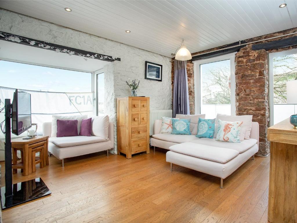 布里克瑟姆Friday Cottage的客厅配有2张白色沙发和电视
