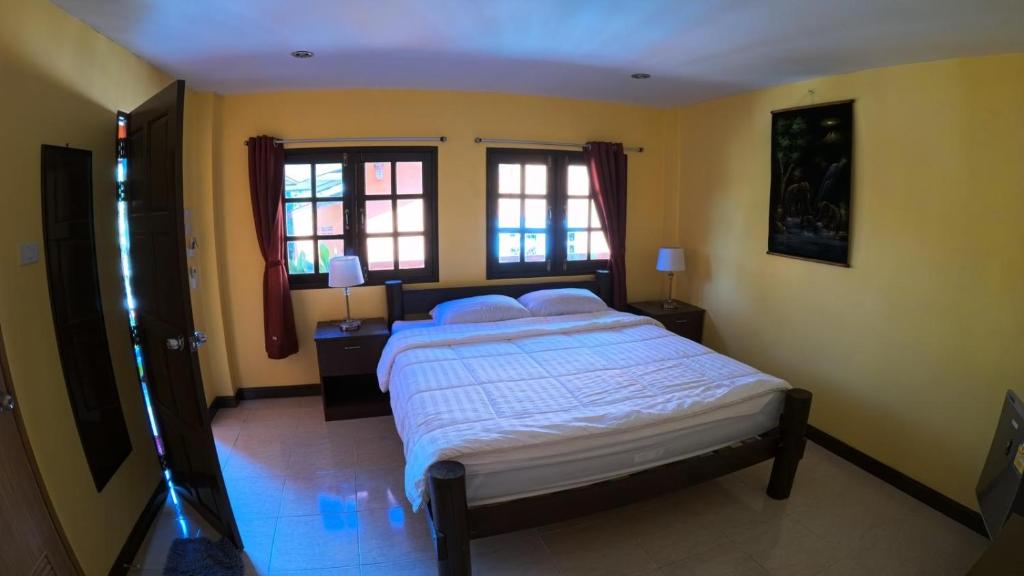 象岛Sapparot Bar & Bungalows的一间卧室设有一张大床和两个窗户。