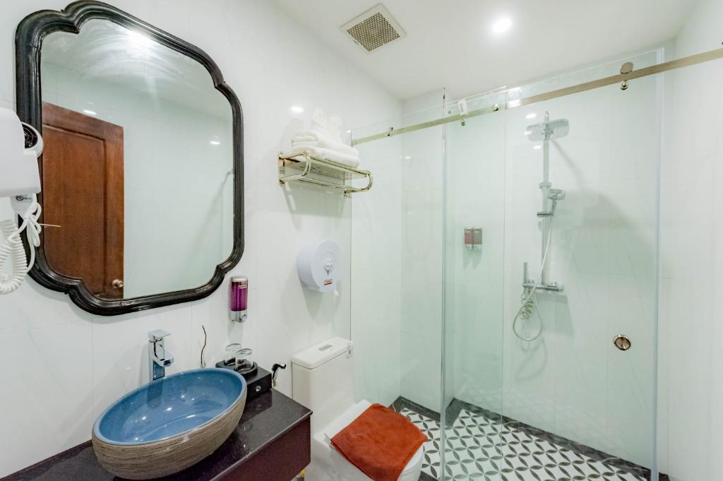 琅勃拉邦Cozy An Boutique Hotel Luangprabang的浴室配有盥洗盆和带镜子的淋浴