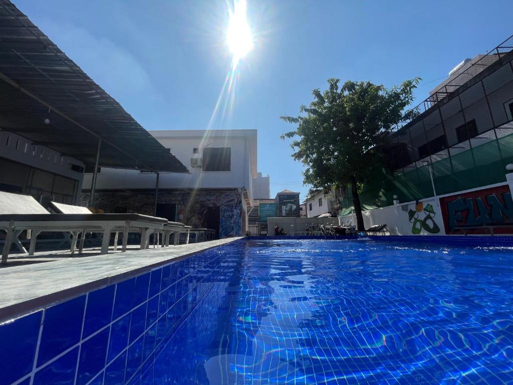 万象Vientiane Garden Hostel的一个大型蓝色游泳池,背面是阳光