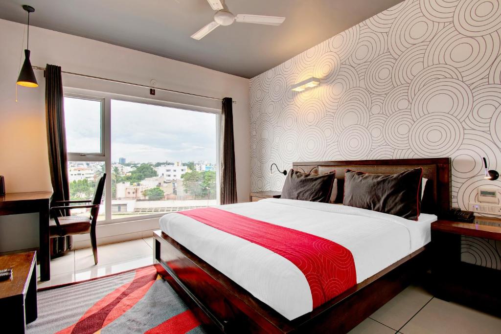 班加罗尔Super Collection O Palm Tree Ulsoor的一间卧室设有一张大床和一个窗户。