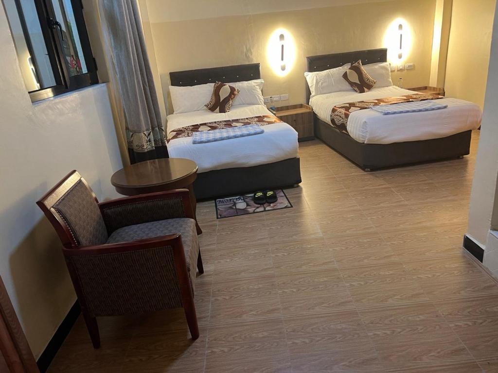 阿克苏姆Hotel 21的酒店客房,配有两张床和椅子