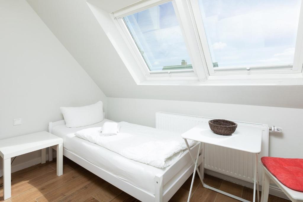 于斯德Haus Delft Ilmenau的白色的客房设有窗户和长凳