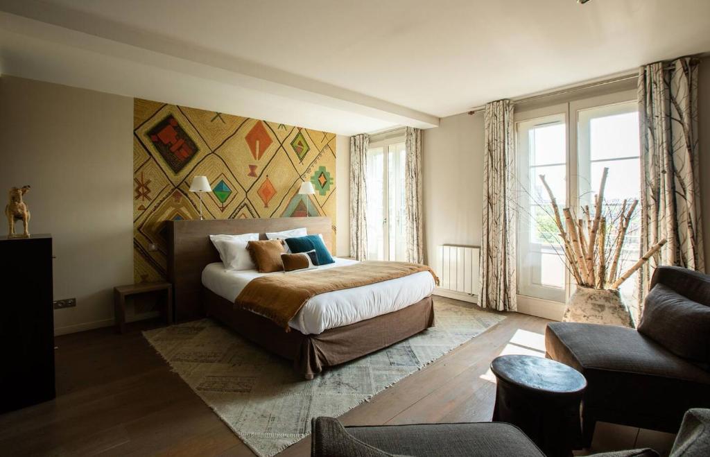 里摩日VILLA FLEURY - APPART'HÔTEL DE STANDING的一间卧室配有一张大床和一张沙发