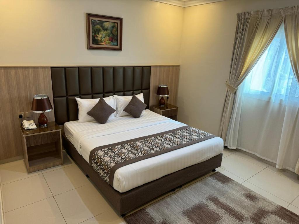 吉达PRIMOTEL Suites As Salamah的一间卧室设有一张大床和一个窗户。