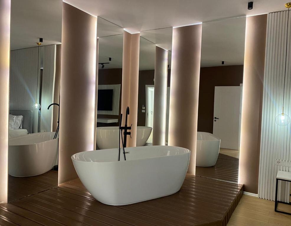 地拉那Capital Suites Center的带浴缸、两个盥洗盆和镜子的浴室