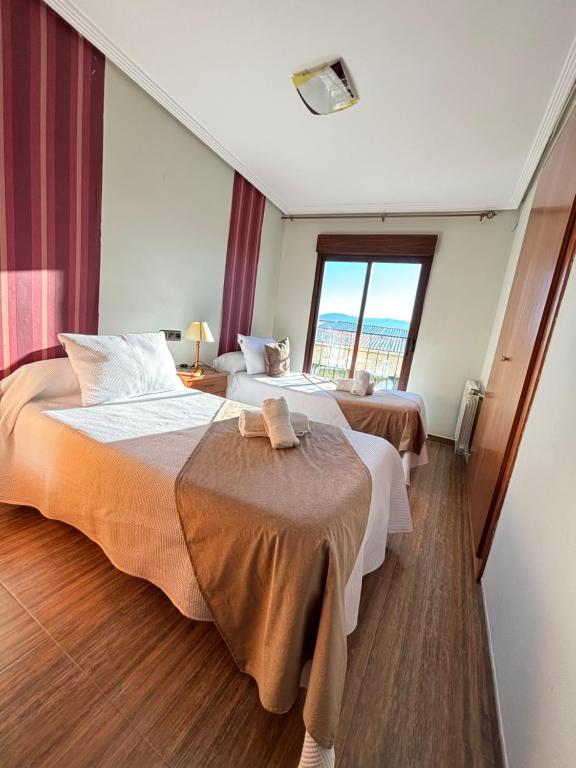 IznatorafCasa Enmedio的酒店客房设有两张床和窗户。