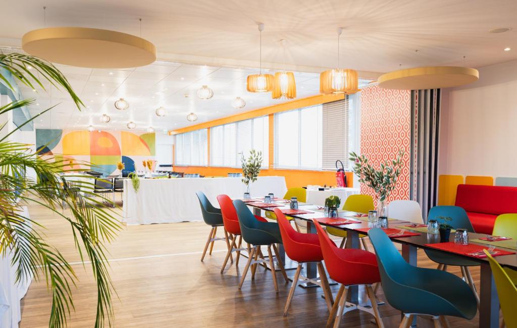 罗讷河畔沙斯南里昂维埃纳水星酒店的一间带桌椅和柜台的餐厅
