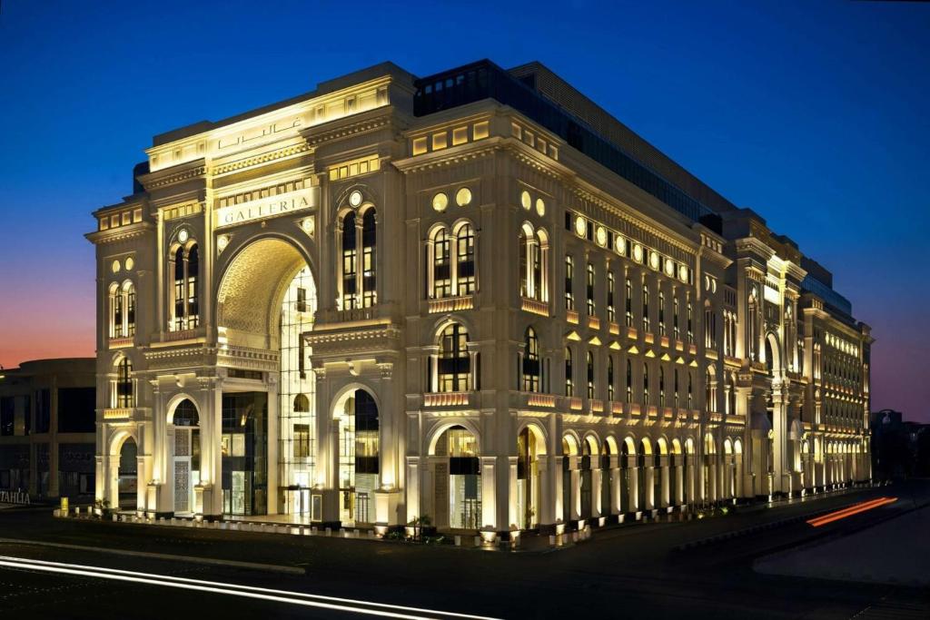 吉达The Hotel Galleria Jeddah, Curio Collection by Hilton的一座白色的大建筑,灯火通明