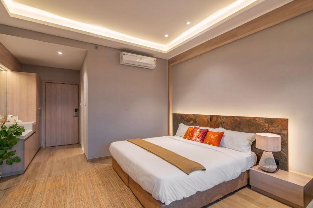 NadiādHOTEL ICON的卧室配有带橙色枕头的大型白色床