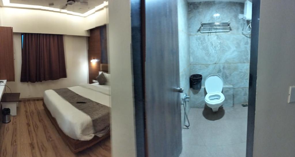 艾哈迈达巴德HOTEL RJ RESIDENCY的浴室设有1张床和带卫生间的淋浴。