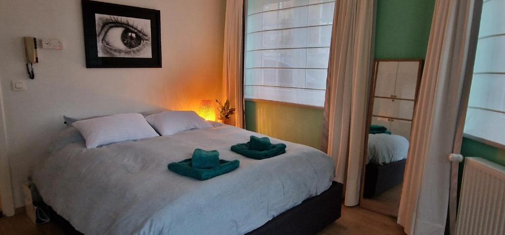 斯帕Bulle D'eau的一间卧室配有一张带两个绿色枕头的床