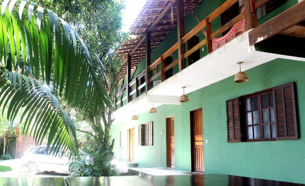 乌巴图巴Sarue Lodge的一座绿色建筑,前面有棕榈树