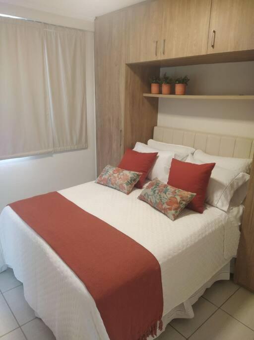 巴西利亚Apartamento Aconchegante的一间卧室配有一张带红色枕头的大床