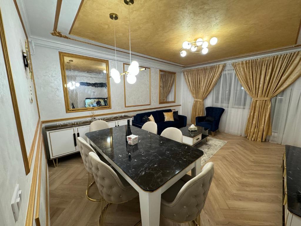 苏恰瓦FancyLux Apartament的一间带桌椅和沙发的用餐室
