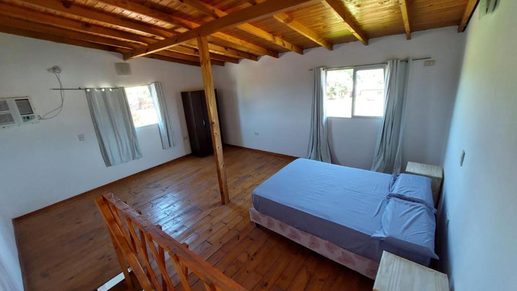 伊瓜苏港Ñandubay1的一间卧室设有一张床和两个窗户。