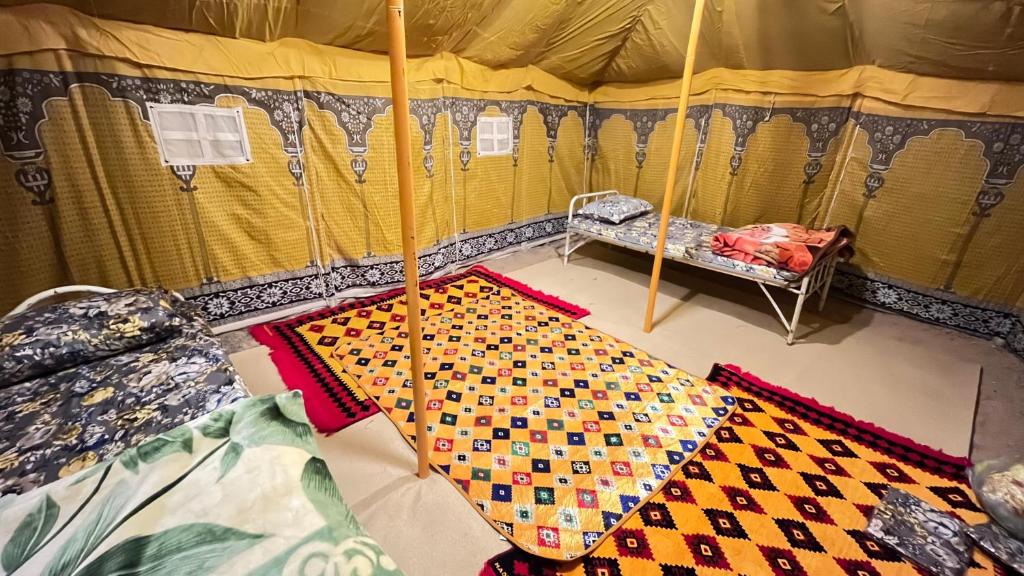 Mogayraمزرعة القمة的帐篷内提供一张床和一把雨伞