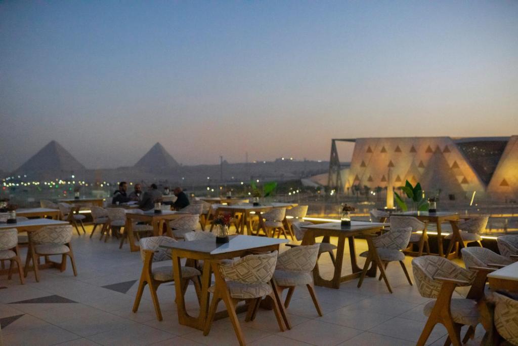 开罗Royal Great Pyramid INN的屋顶上一组有金字塔的桌椅