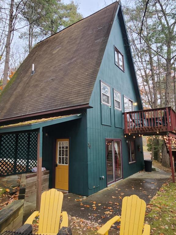 乔治湖Adirondack Diamond Point Lodge的蓝色房子前面有两把椅子