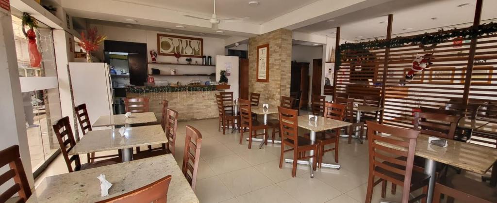 皮斯科Hostal El Candelabro的餐厅内带桌椅的用餐室