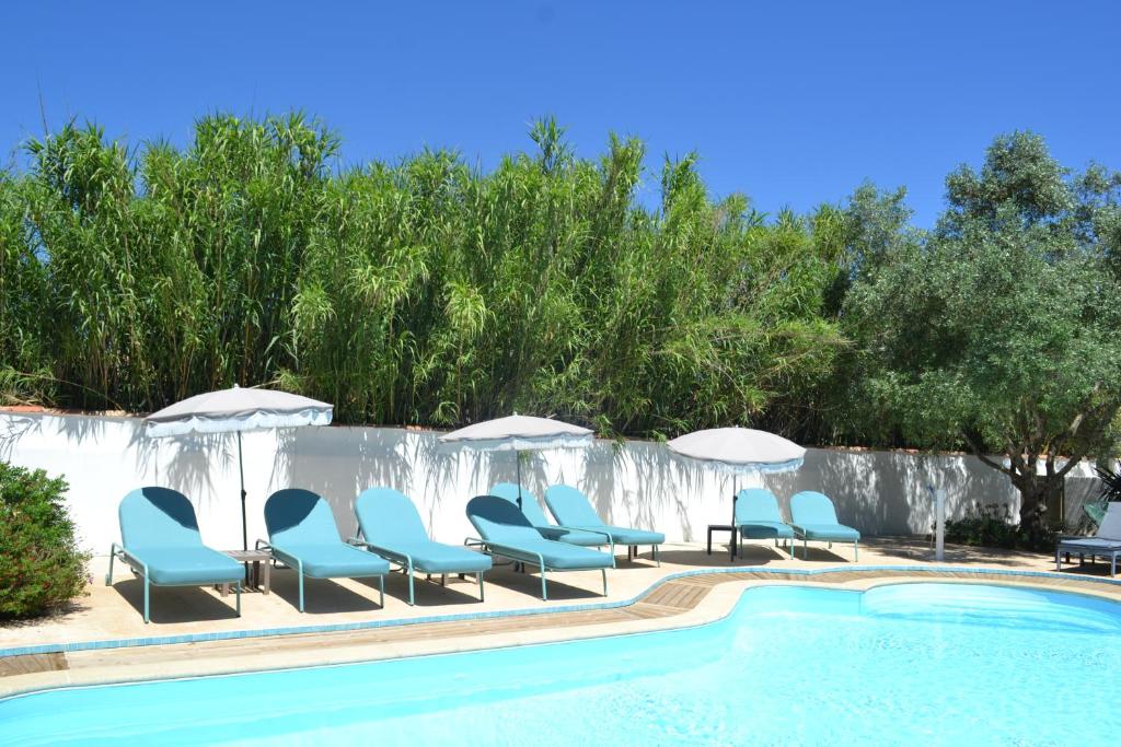奥雷龙圣皮耶尔亚特兰提克酒店的游泳池旁设有躺椅和遮阳伞的游泳池