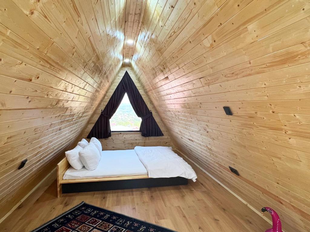 卡特佩Kartepe Vista Bungalov的木制客房的一张小床,设有窗户
