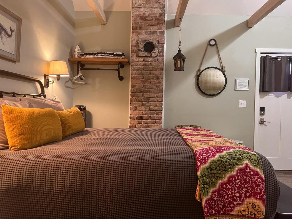 西塞德Sea Glass Inn的一间卧室设有一张床和砖墙