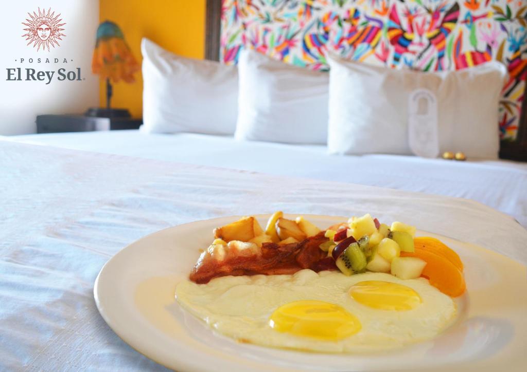 恩塞纳达港波萨达埃雷伊索尔酒店的床上一盘带鸡蛋和水果的食物