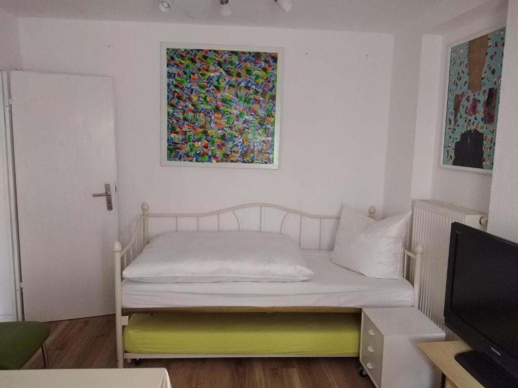 沃尔姆斯Appertment im Garten的一间小卧室,配有一张床和墙上的绘画