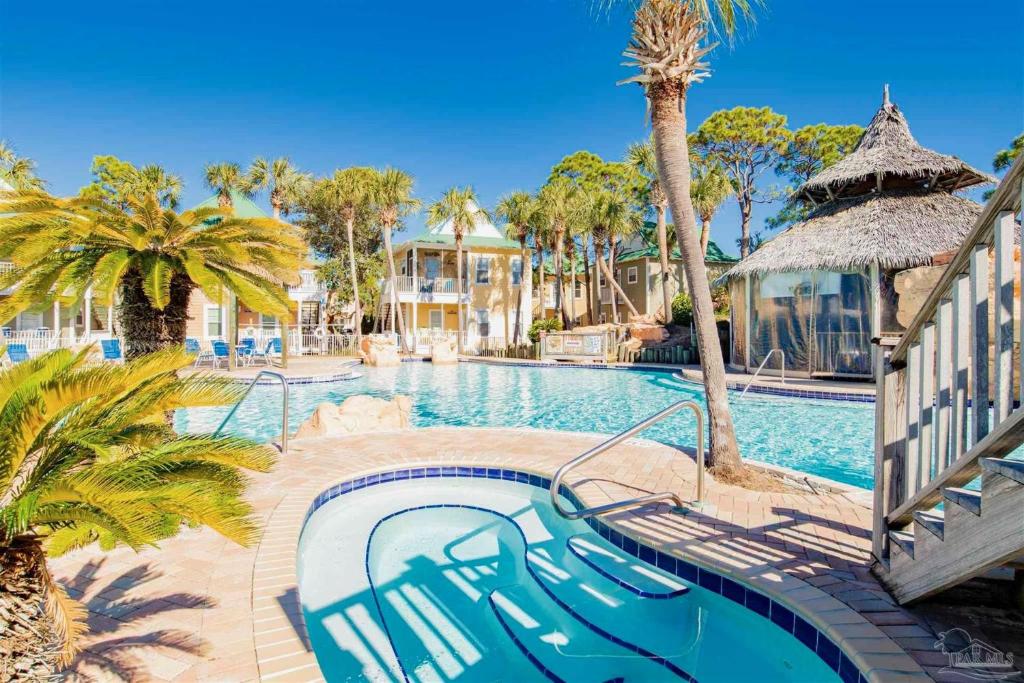 佩尔迪多基Perdido Key Purple Parrot Resort的棕榈树游泳池及度假村