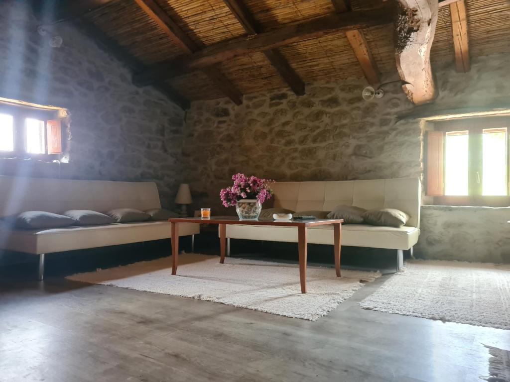 UsellusCasa di Pietra的一间设有两张床的房间和一张鲜花桌子