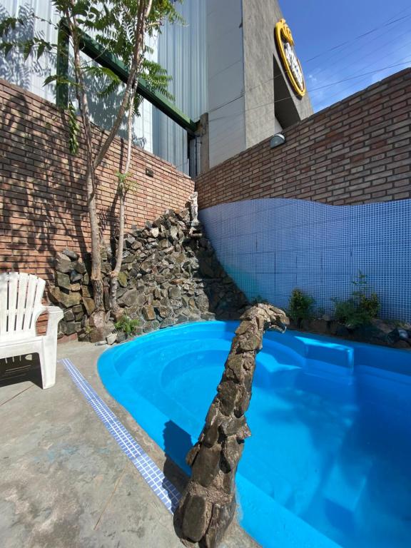 门多萨卢卡波多旅舍的一座带石墙的庭院内的游泳池