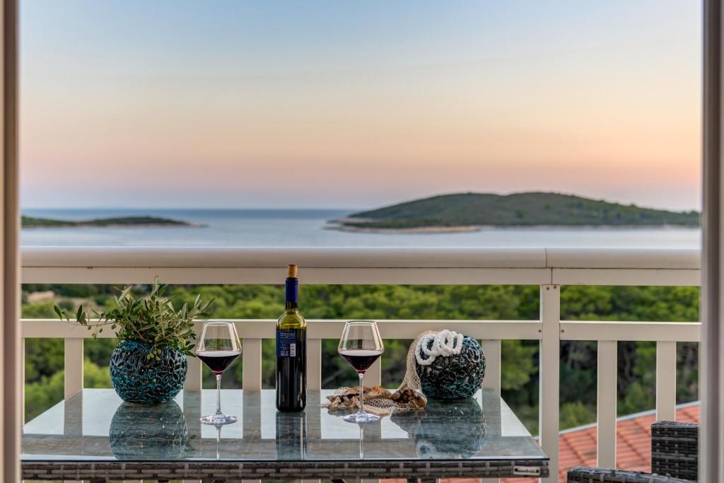 赫瓦尔B&B Paradiso - Pakleni Islands Hvar的阳台上的桌子和两杯葡萄酒