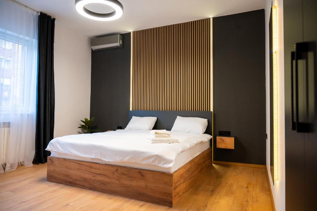 斯科普里Casa Central Apartments Skopje的一间卧室配有一张带白色床单的大床