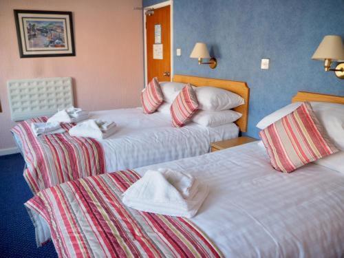 伯恩茅斯Devon Towers Hotel的酒店客房,配有两张带毛巾的床