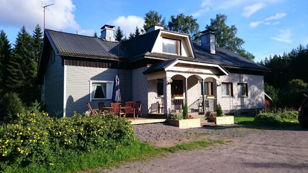 BillnäsMetsäniityn Tuvat的黑色屋顶的白色房子