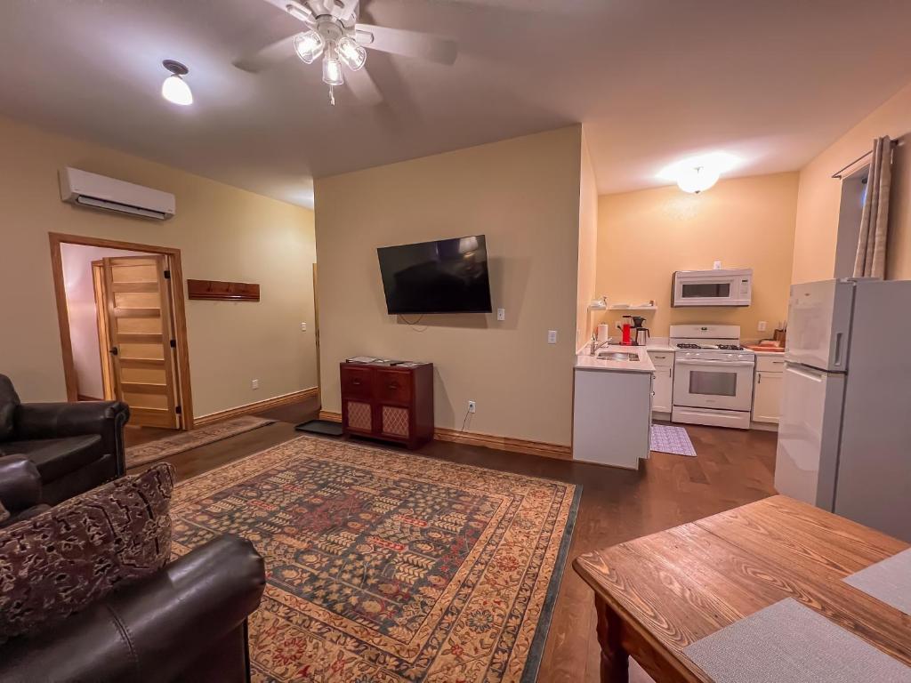 ElkaderGoldfinch Suites的客厅配有沙发和墙上的电视