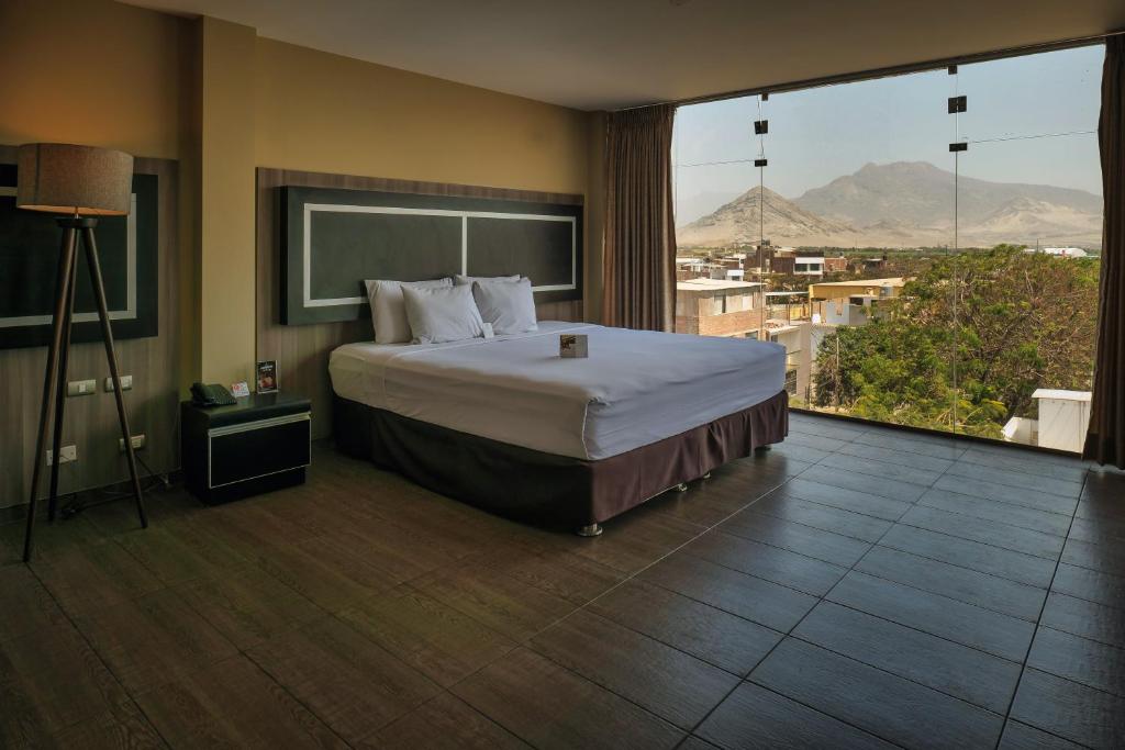 特鲁希略Rado Hotel - Santa María的一间卧室设有一张大床和一个大窗户