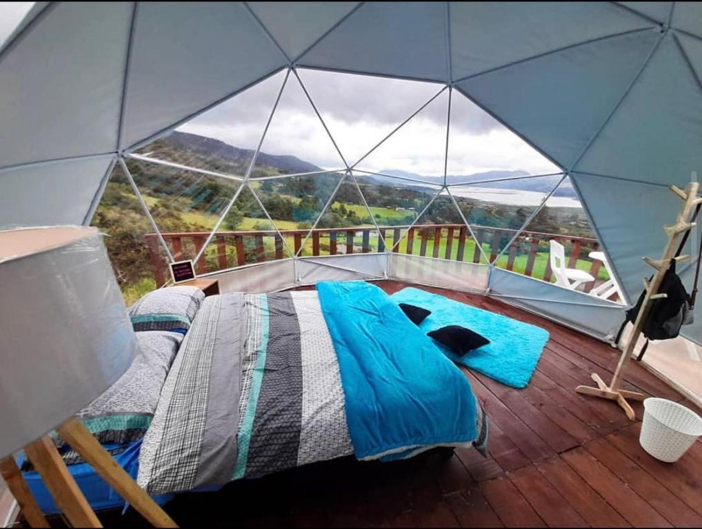 SantuarioSkyline Glamping的美景圆顶帐篷内的一张床位