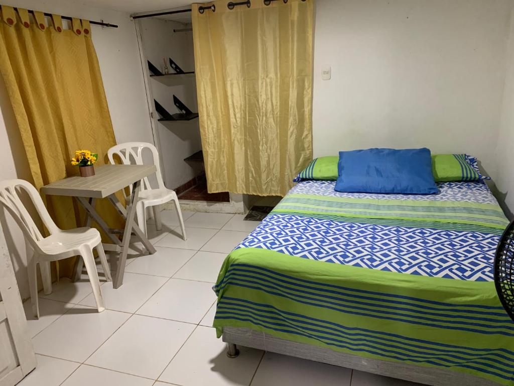 Puerto SalgarHabitación independiente cerca al mar.的卧室配有一张床和一张桌子及椅子