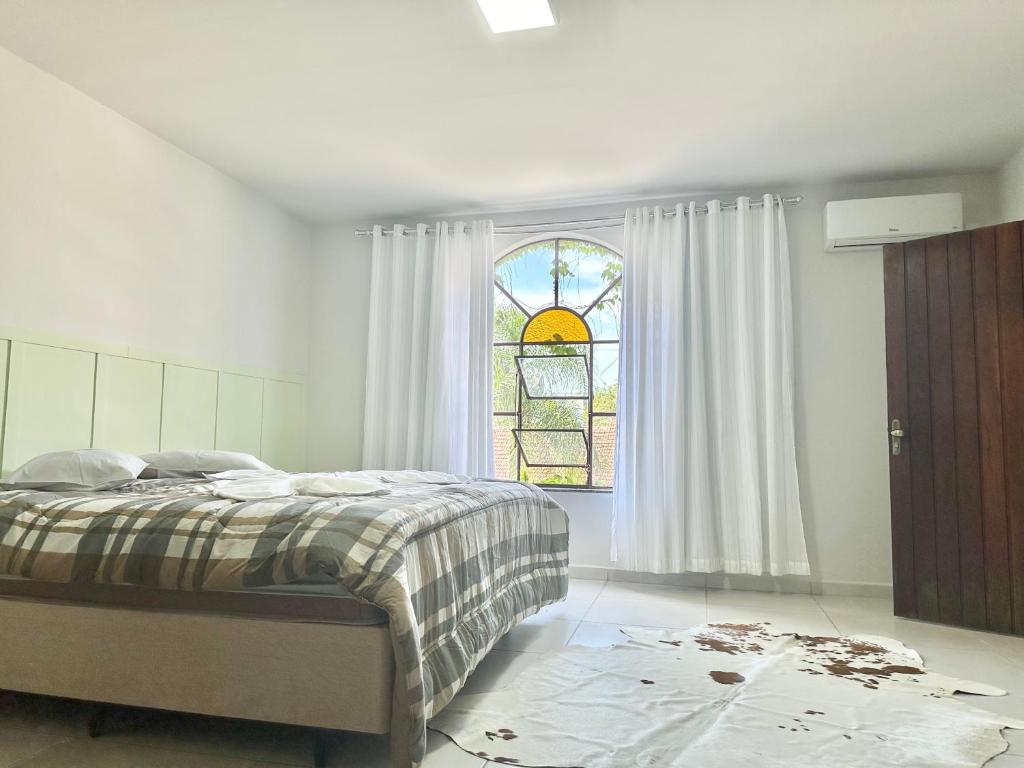 波梅罗迪Suíte na casa amarela的一间卧室设有一张床和一个窗口